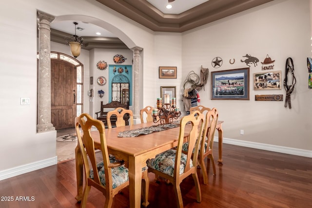 dining room with dark wood-type flooring and decorative columns