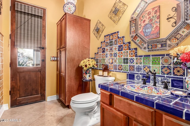 bathroom with tile patterned flooring, vanity, and toilet