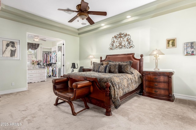 carpeted bedroom with a spacious closet, ceiling fan, and a closet