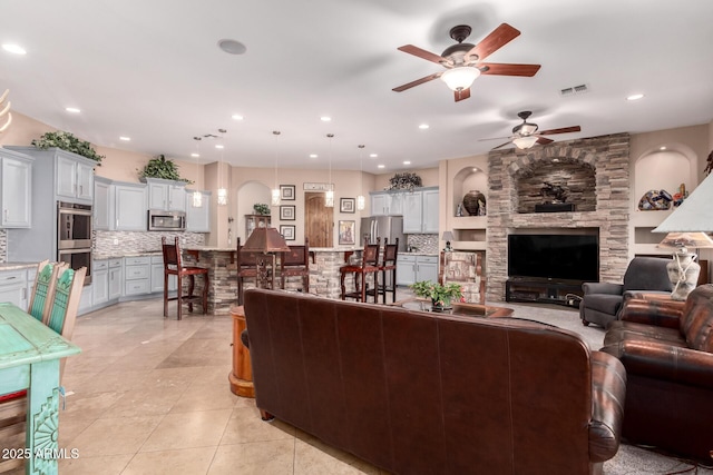 living room featuring light tile patterned floors and ceiling fan