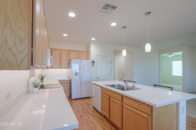 kitchen featuring a center island with sink, ceiling fan, white appliances, hanging light fixtures, and sink