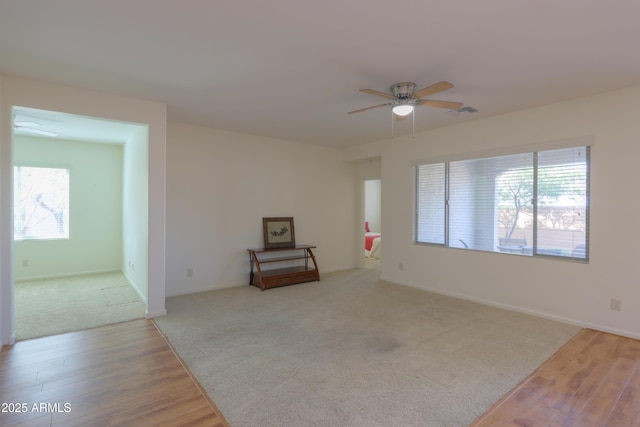 carpeted empty room featuring ceiling fan and a wealth of natural light