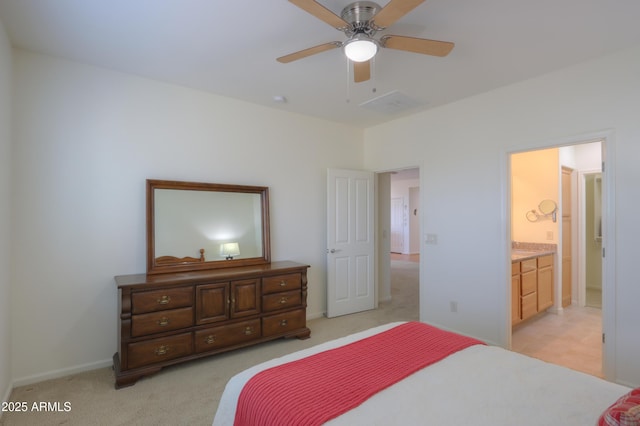 bedroom featuring light carpet, ceiling fan, and ensuite bathroom