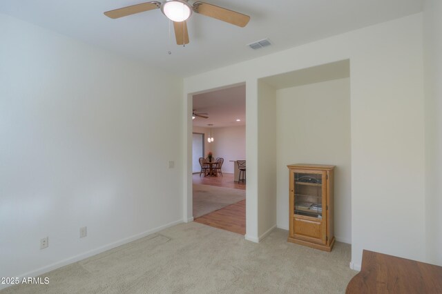 unfurnished room with ceiling fan and light carpet