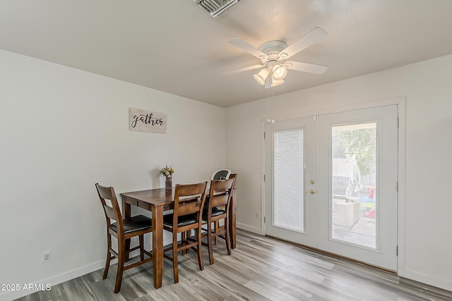 dining room featuring ceiling fan, french doors, visible vents, light wood-type flooring, and baseboards