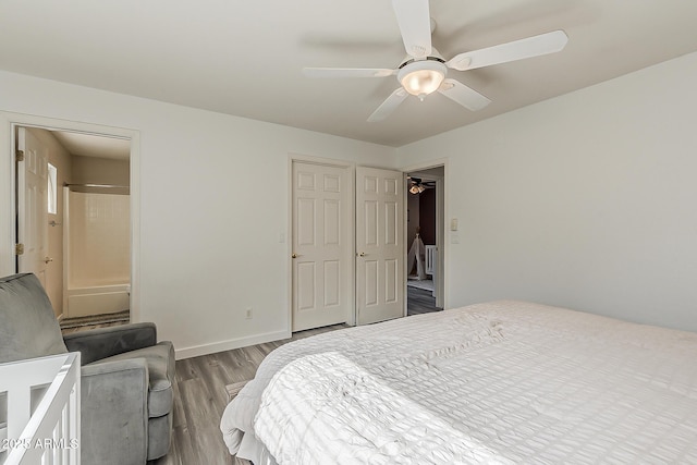 bedroom featuring connected bathroom, a ceiling fan, baseboards, and wood finished floors