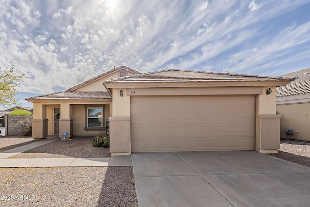 view of front facade with an attached garage, stucco siding, driveway, and a tile roof
