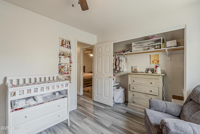 bedroom with ceiling fan, light wood-style flooring, and a closet