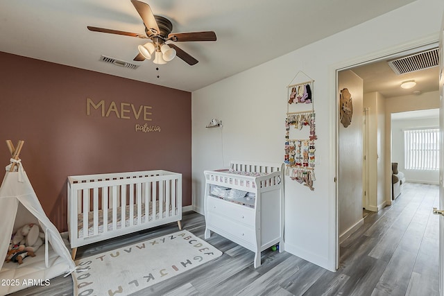 bedroom featuring baseboards, visible vents, and wood finished floors