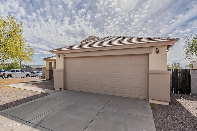 garage with fence and driveway
