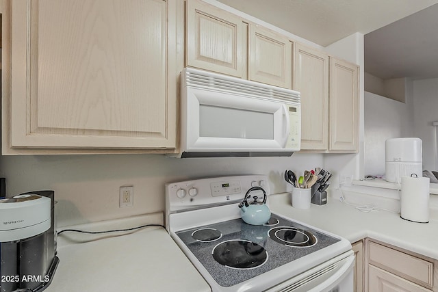 kitchen with white appliances, light brown cabinetry, and light countertops