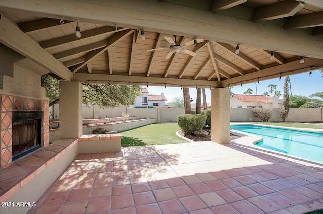 view of patio with an outdoor stone fireplace, ceiling fan, and a gazebo