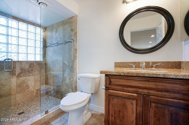 bathroom featuring tile patterned floors, vanity, toilet, and a shower with door