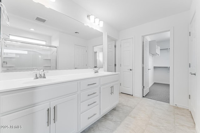 full bathroom with a sink, double vanity, visible vents, and baseboards