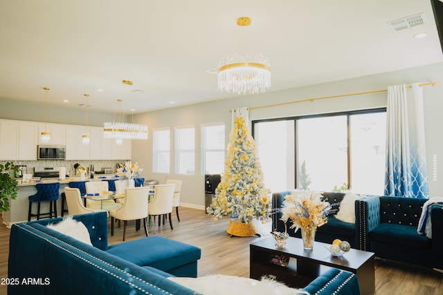 living room with a chandelier and light hardwood / wood-style floors