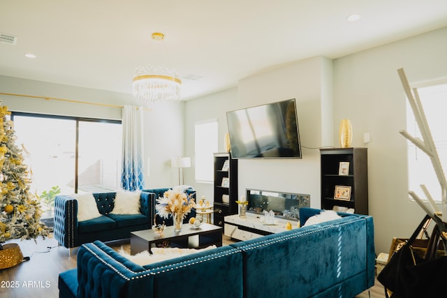 living room with an inviting chandelier, a fireplace, and hardwood / wood-style flooring