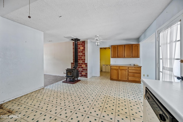 312 W Saddle Ln, Payson, AZ 85541 - kitchen featuring dishwasher, light countertops, light floors, a ceiling fan, and a wood stove