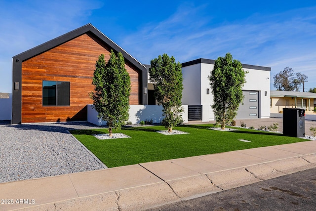 contemporary house featuring a front yard and stucco siding