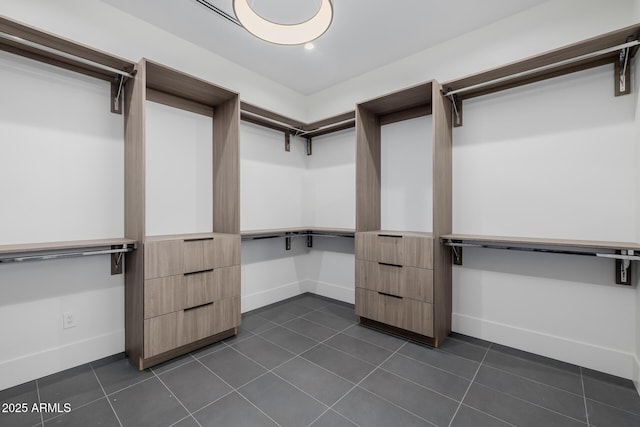 walk in closet featuring dark tile patterned flooring