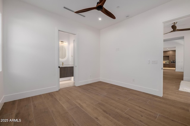 spare room with recessed lighting, wood finished floors, a ceiling fan, and baseboards