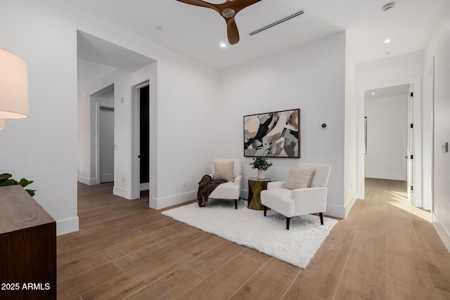 living area with light wood finished floors, recessed lighting, visible vents, ceiling fan, and baseboards