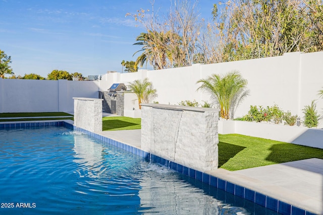 view of pool featuring a fenced in pool, a patio, an outdoor kitchen, area for grilling, and a fenced backyard