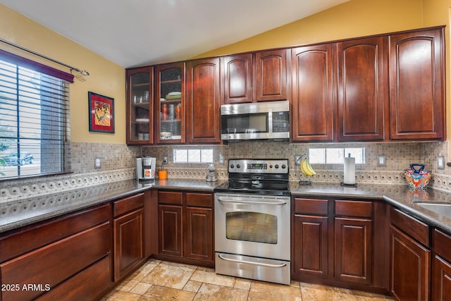 kitchen featuring tasteful backsplash, vaulted ceiling, appliances with stainless steel finishes, and sink