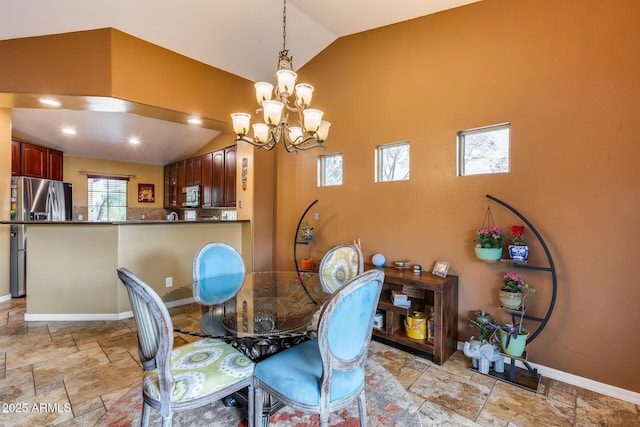 dining room with lofted ceiling and a chandelier