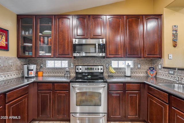 kitchen with stainless steel appliances, tasteful backsplash, vaulted ceiling, and sink