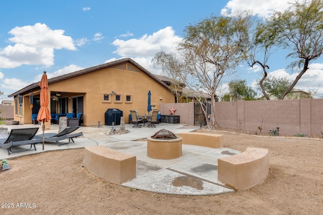 back of house featuring a patio area and a fire pit