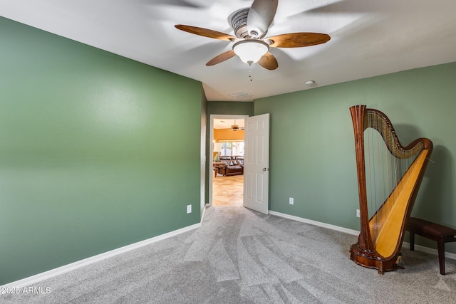 carpeted spare room featuring ceiling fan