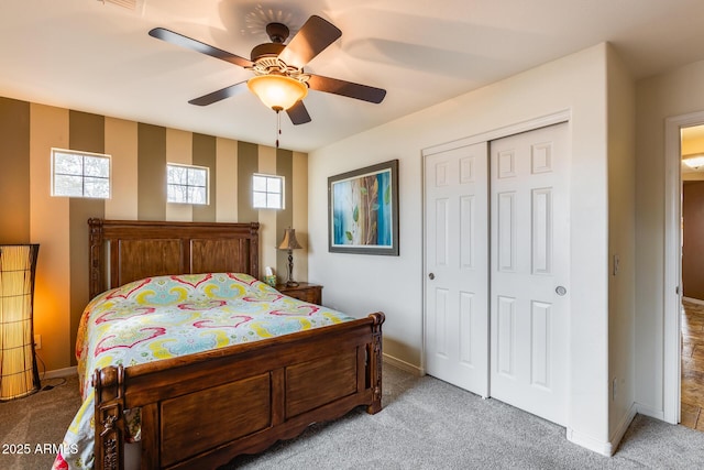 carpeted bedroom with ceiling fan and a closet