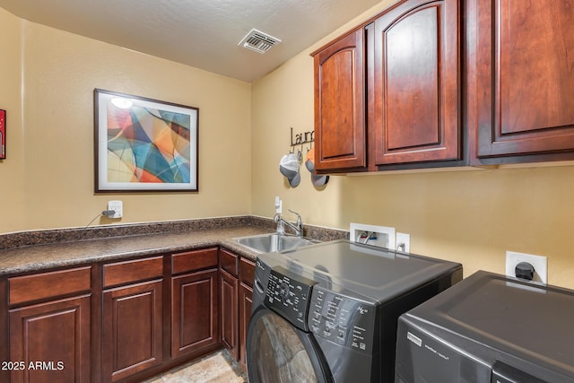 clothes washing area featuring separate washer and dryer, sink, and cabinets