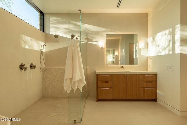 full bath featuring visible vents, vanity, and a tile shower