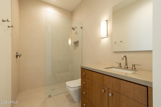 full bathroom with tile patterned floors, toilet, a tile shower, tile walls, and vanity