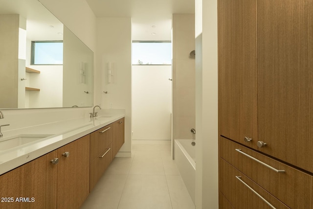 bathroom featuring tile patterned floors, double vanity, bathing tub / shower combination, and a sink