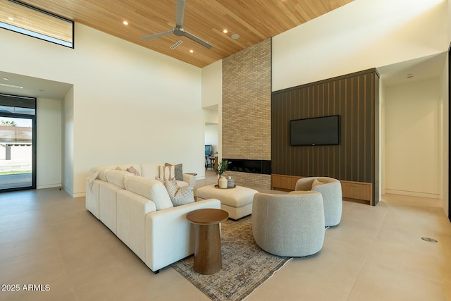 living area with recessed lighting, wood ceiling, baseboards, and a towering ceiling