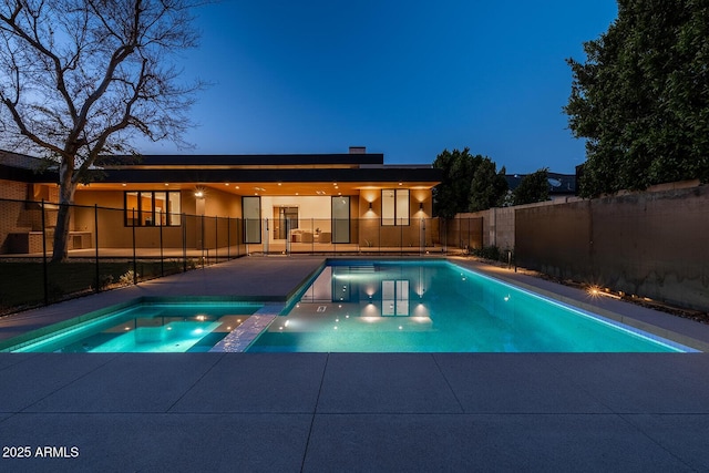 view of swimming pool featuring a patio, a fenced backyard, and a pool with connected hot tub