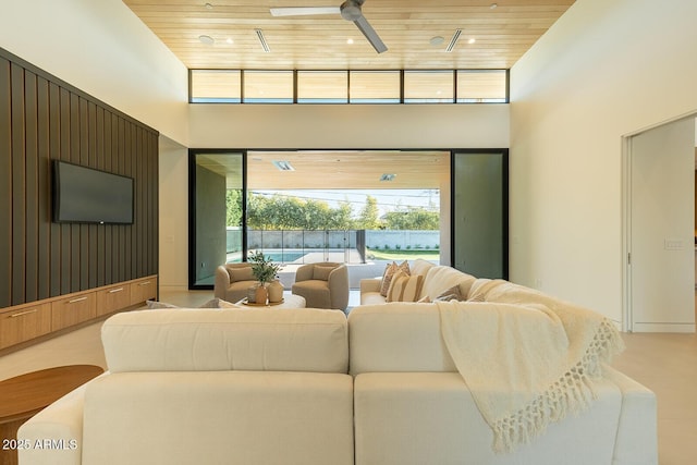 living room featuring ceiling fan, wood ceiling, and a towering ceiling