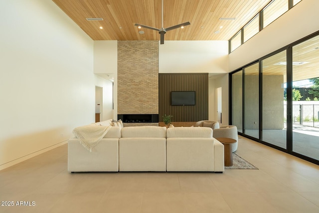 living area featuring visible vents, a brick fireplace, a high ceiling, and wood ceiling