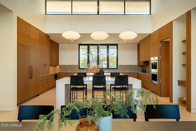 kitchen featuring light countertops, a kitchen breakfast bar, modern cabinets, and a kitchen island