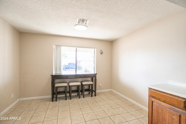 tiled dining space with a textured ceiling