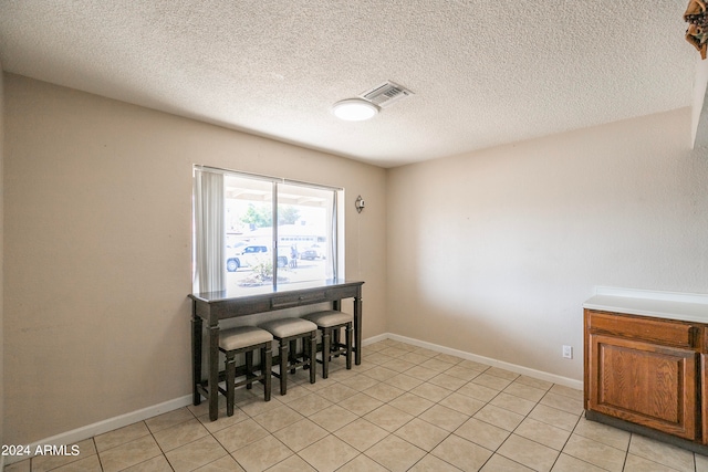 dining space with light tile patterned flooring and a textured ceiling