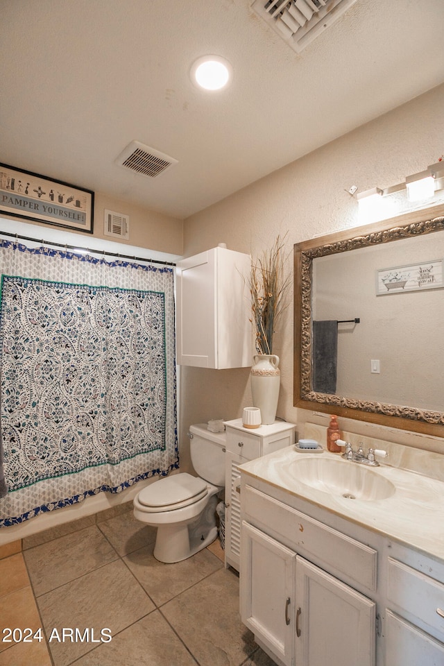 bathroom with walk in shower, vanity, tile patterned floors, toilet, and a textured ceiling