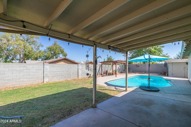 view of pool featuring a lawn and a patio