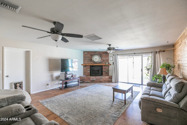 living room featuring a fireplace, hardwood / wood-style floors, and ceiling fan