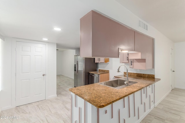 kitchen with kitchen peninsula, light stone countertops, sink, and stainless steel appliances