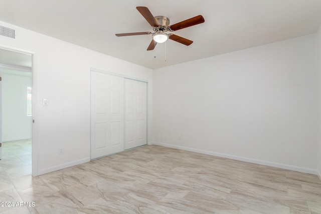 unfurnished bedroom featuring ceiling fan and a closet