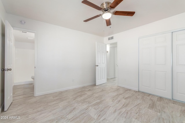 unfurnished bedroom with ceiling fan and a closet