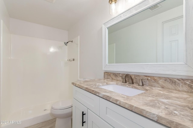 bathroom with vanity, toilet, and walk in shower